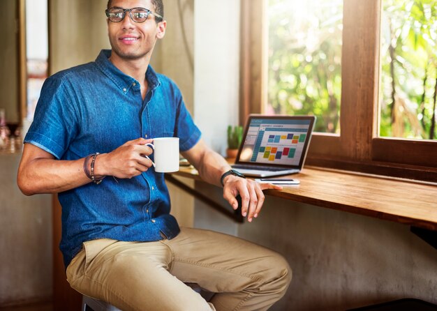 Homme travaillant au café connectant le concept de portable