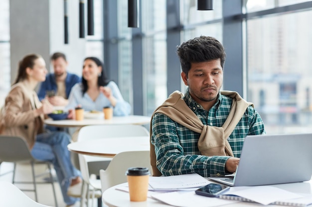 Homme travaillant à distance à la table du café