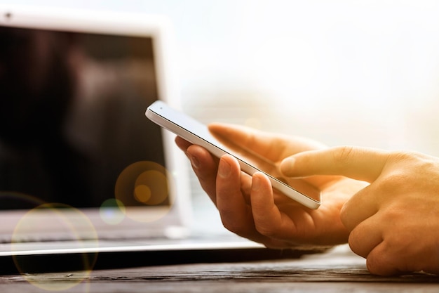 Homme travaillant à domicile à l'aide d'un téléphone intelligent