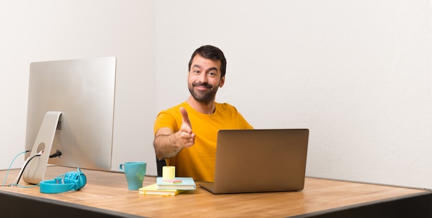 Homme travaillant avec laptot dans un bureau se serrant la main pour conclure une bonne affaire