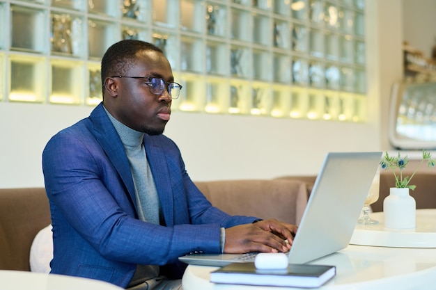 Homme travaillant en ligne au café