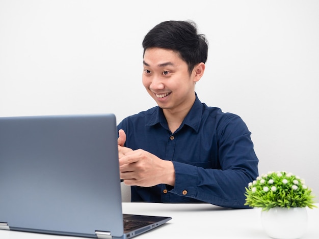 Homme travaillant en ligne avec un ordinateur portable sur la table, homme gai utilisant un ordinateur portable appelant son travail