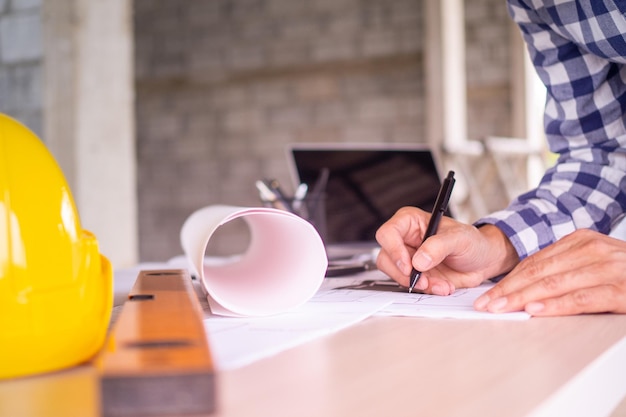 Homme travaillant à la main du projet d'esquisse de l'architecte sur le plan des travaux de construction du site. Concept d'architecte, ingénieur dans la bannière de projet de construction de bureau