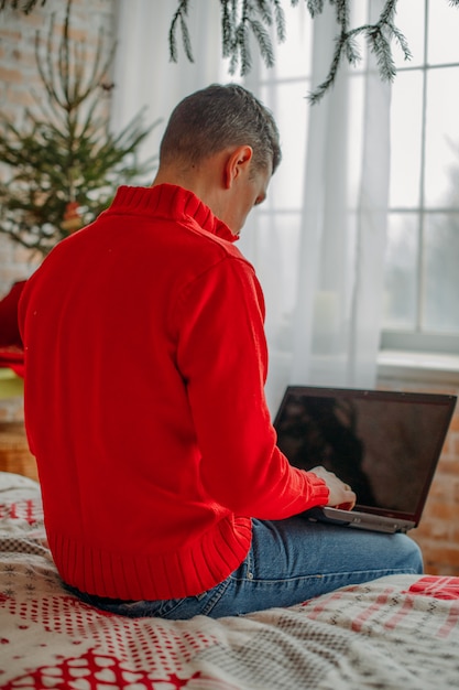 Homme travaillant avec un ordinateur portable dans la chambre