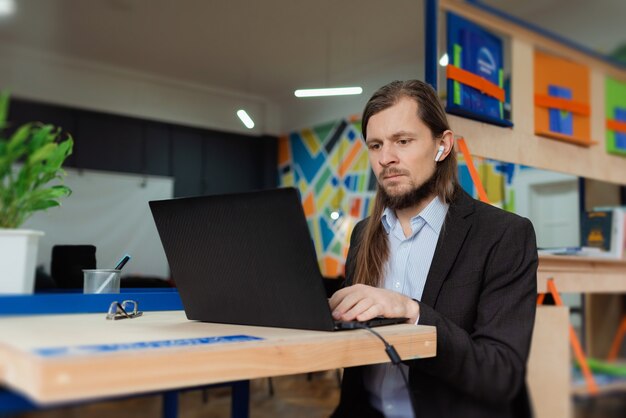 Un homme travaillant sur un ordinateur portable dans un coworking coloré