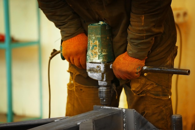 Homme travaillant avec une perceuse dans un garage