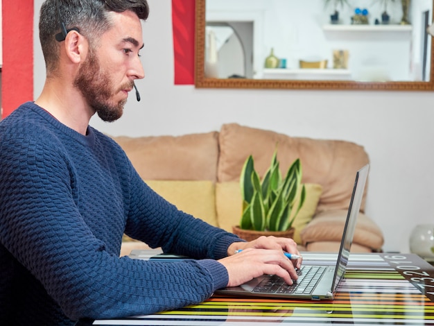 Photo homme travaillant sur son ordinateur à la maison