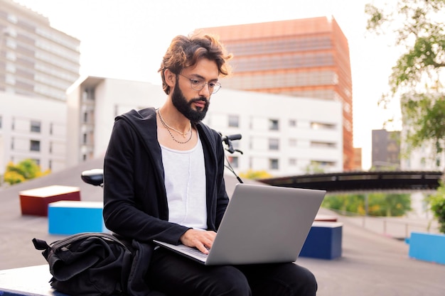 Homme travaillant sur son ordinateur portable sur le campus universitaire