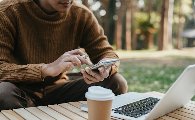 Homme travaillant avec un téléphone intelligent et un ordinateur portable.