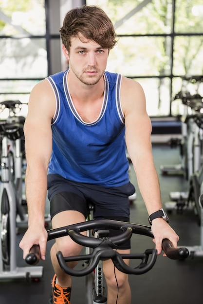 Homme travaillant sur un vélo d'exercice au cours de spinning