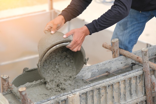 Homme travaillant à verser du béton dans une structure