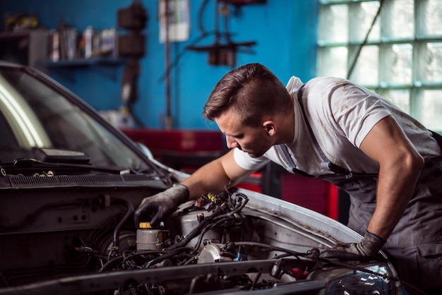 Un homme travaillant sur une voiture dans un garage