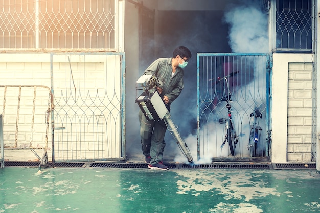 L&#39;homme travaille à la brumisation pour éliminer les moustiques