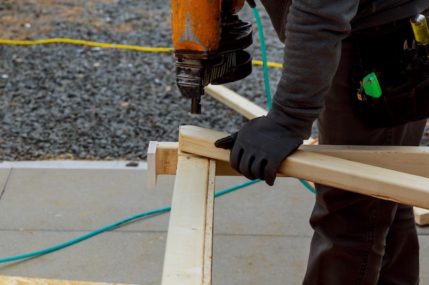 Un homme travaille à la construction d&#39;un mur de maison. Il est sur une échelle de tir cadré horizontalement.