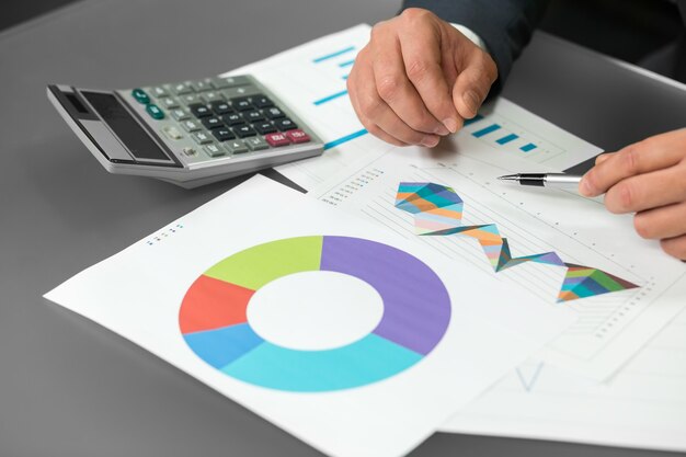 L'homme travaille avec graphique. Tableau de progression. Rapport d'étape. Construire de nouvelles stratégies.