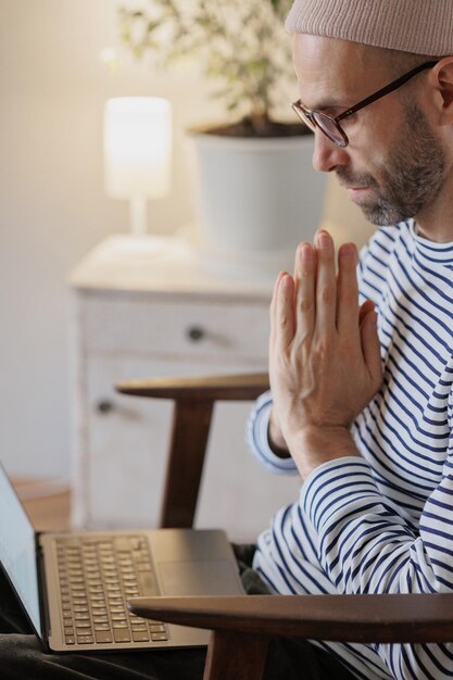 L'homme travaille sur un ordinateur portable à la maison un designer indépendant ou un top manager travaille en ligne ou regarde un