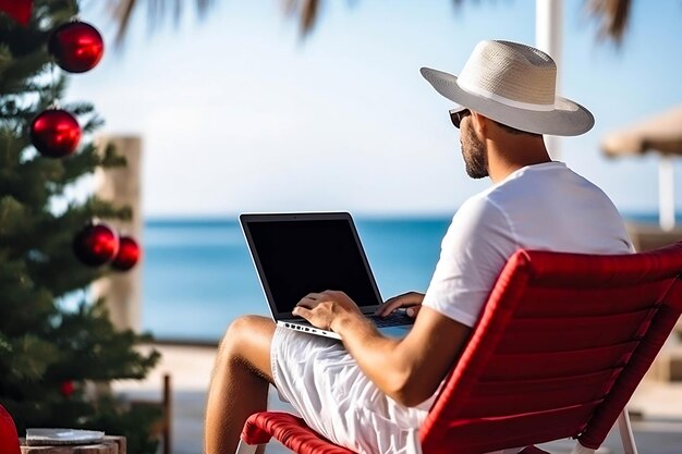 L'homme travaille sur un ordinateur portable sur la plage