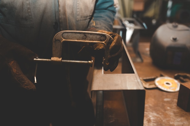 L'homme travaille avec des pinces. Concept d'atelier en acier