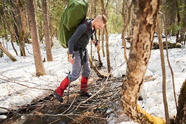 Un homme traversant un ruisseau dans une forêt