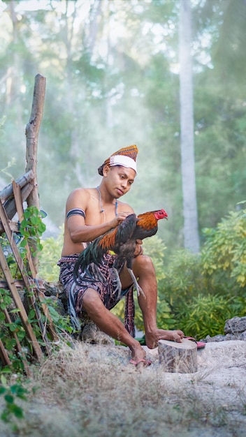 Un homme de la tribu Sabu-Raijua tenant un coq