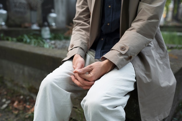 Homme triste assis sur la tombe au cimetière