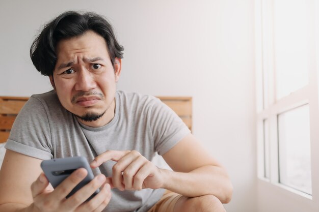 Un homme triste a de mauvaises nouvelles sur le chat en ligne et se sent déçu sur le smartphone