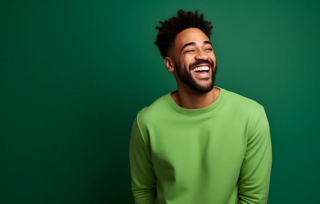 Un homme ultra beau souriant et riant portant des vêtements lumineux un fond vert solide lumineux