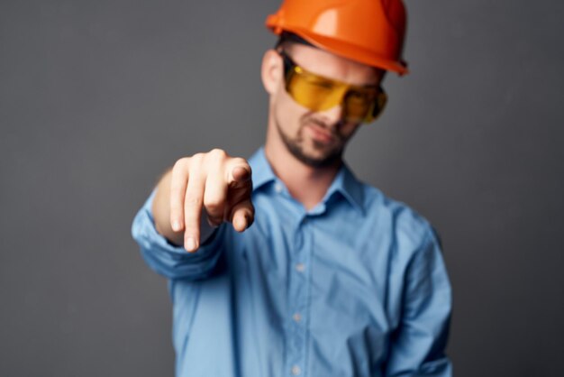 Homme en uniforme de construction chemise bleue gestes mains émotions travail photo de haute qualité