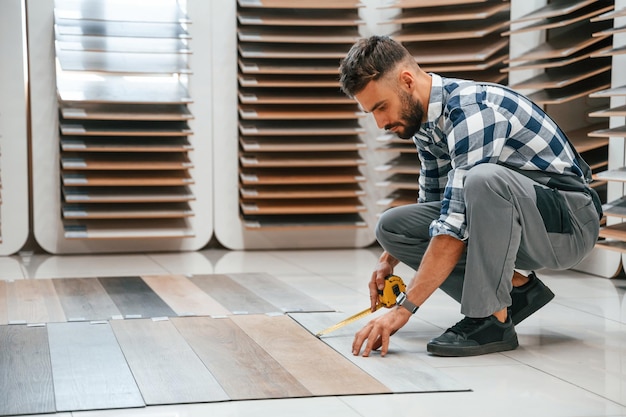 L'homme en uniforme gris est avec du parquet à l'intérieur