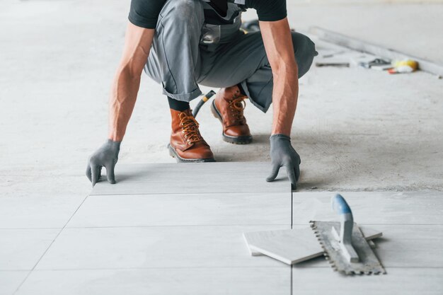 L'homme en uniforme gris travaille à l'intérieur dans un grand bureau moderne pendant la journée