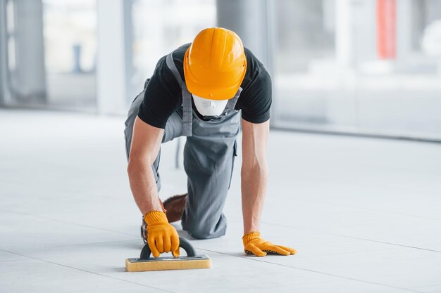 L'homme en uniforme gris travaille à l'intérieur dans un grand bureau moderne pendant la journée