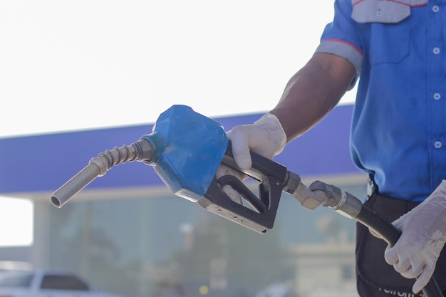 Homme utilisant une machine à essence travailleur de la station-service portant des gants pour la protection covidx9