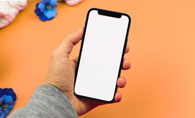 Homme utilisant une maquette de smartphone avec écran blanc vierge, concept de conception d'espace de travail à plat