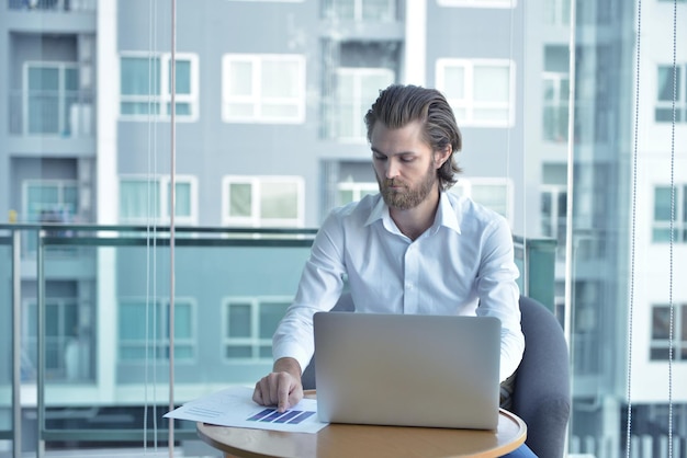 Homme utilisant un ordinateur portable alors qu'il est assis au bureau