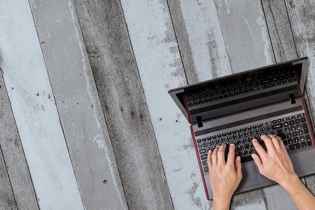 un homme utilisant un ordinateur portable avec des arrière-plans en bois gris xA