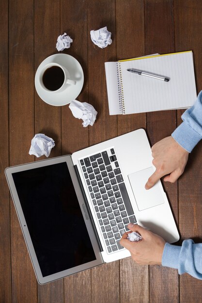 Homme utilisant un ordinateur portable lors de l'écriture sur le bloc-notes