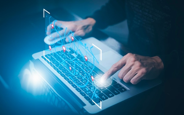 Homme utilisant un ordinateur portable avec un monde virtuel et une carte modèle avec l'icône de l'application GPS de point de localisation Cartes de voyage et trouver des lieux dans le système en ligne tous les graphiques d'écran sont générésRecherche de voyage