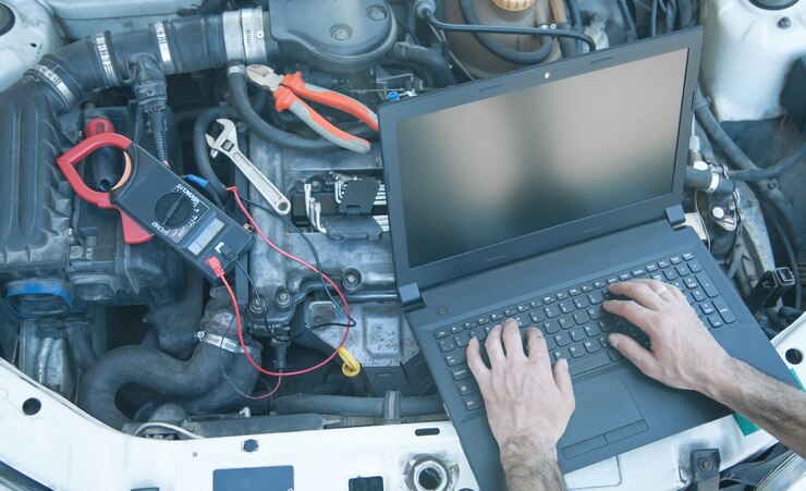 Photo homme utilisant un ordinateur portable. moteur de voiture de diagnostic