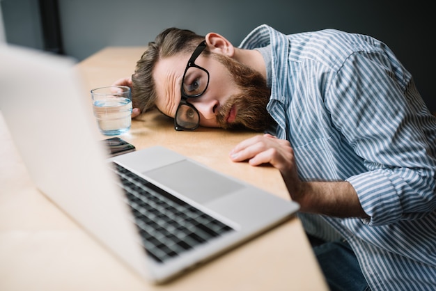 Homme utilisant un ordinateur portable, se sentant fatigué