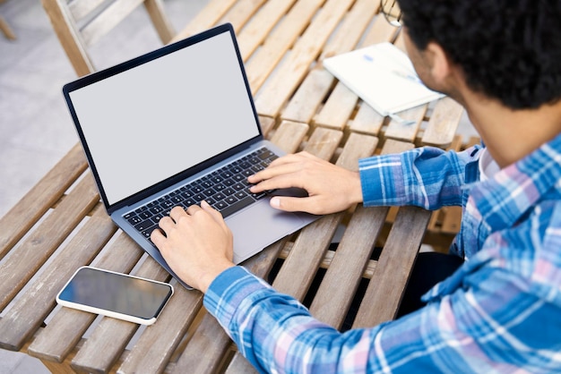 Homme utilisant un ordinateur portable travaillant sur un projet indépendant, tapant, recherchant sur le site Web, maquette