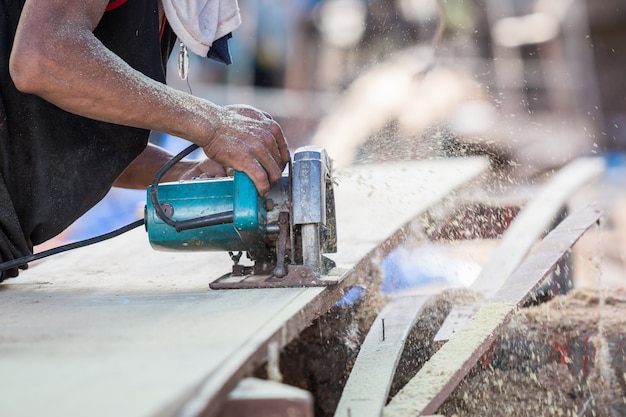 Un homme utilisant une scie circulaire pour couper le bois