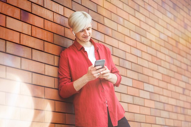 Homme utilisant un service de musique en ligne Jeune hipster avec un casque sans fil