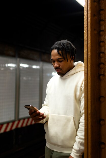 Homme utilisant un smartphone dans le métro de la ville