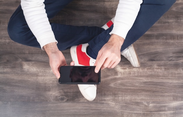 Photo homme utilisant un smartphone à la maison.