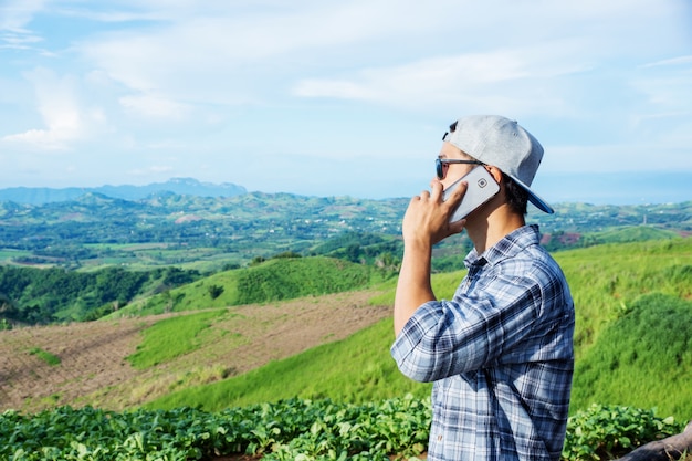 Homme en utilisant un smartphone à la montagne.