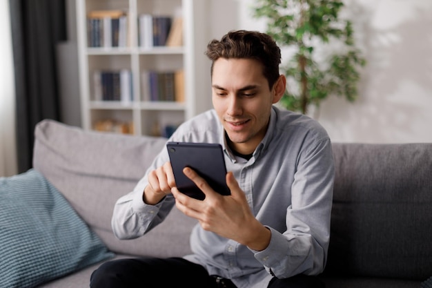 Homme utilisant une tablette sur un canapé