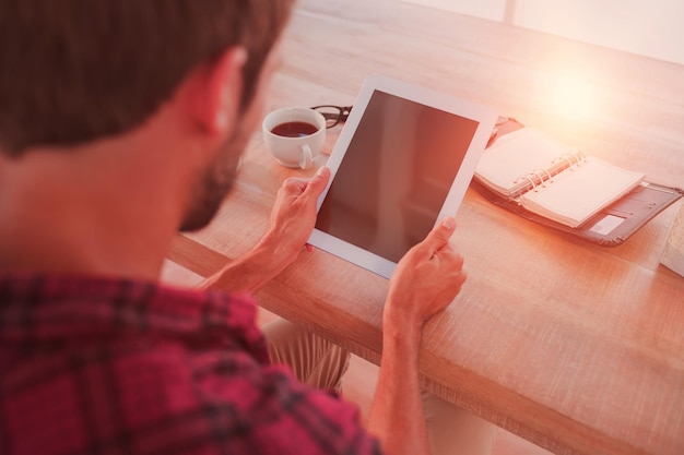 Photo homme utilisant une tablette sur une table en bois au bureau