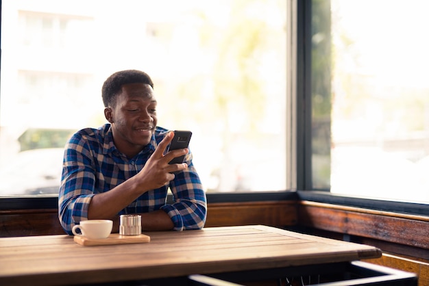 Homme utilisant un téléphone portable assis sur une table
