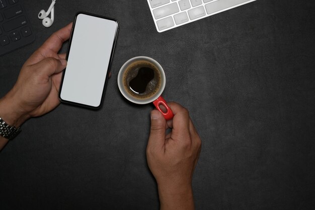 Homme utilisant un téléphone portable sur un bureau en cuir foncé