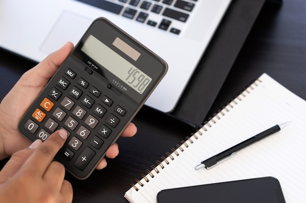 Homme utilise une calculatrice dans un bureau